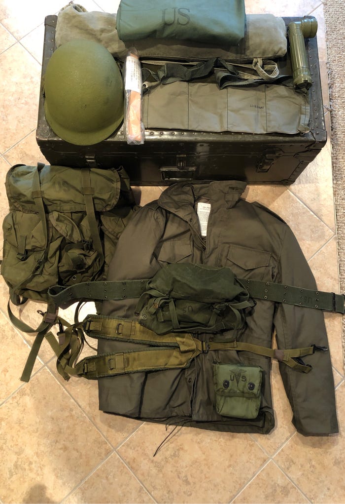 U.S. Army basic issue of gear including steel pot Helmut, flashlight and footlocker.  Biography of Dr. Anthony J. Carbone.