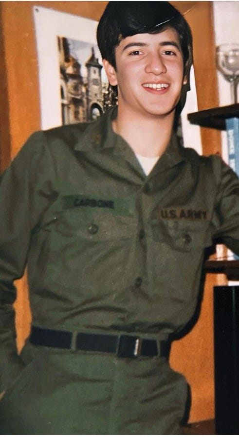 Cadet Anthony J. Carbone wearing olive drab U.S. Army fatigues in his dormitory room.  