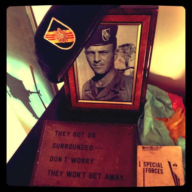 My father’s photo in Ban Me Thuot, Vietnam, his Special Forces manual, Captured Viet Cong Flag, and Placque presented to him by the Officers & Men of MACV-SOG Command & Control South Upon His Departure.  With my father's famous quote:  "THEY GOT US SURROUNDED.  DON'T WORRY, THEY WON'T GET AWAY!"

Part of the autobiography of Dr. Anthony J. Carbone, Son in the Shadow of a Green Beret Hero.