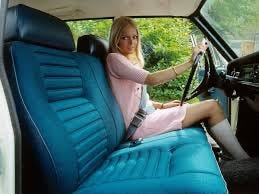 Blonde girl in pink minidress and white boots in the driver's seat of a 1970s-era car with blue bench seats.  Biography of Dr. Anthony J. Carbone.