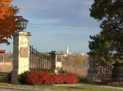 Front Gate to Fort Leavenwork, Kansas where the Command & General Staff College is located.
After returning from his first tour in Vietnam in 1967, my father received prestigious orders to attend the United States Army Command and General Staff College (CGSC) at Fort Leavenworth, Kansas. This wasn’t just another stop on the military carousel — it was a pivotal milestone in his ascending career. Being selected early for CGSC was a mark of distinction. It signaled that the Army saw him not only as a skilled officer but as a leader with long-term potential.

Front Gate to Fort Leavenworth, Kansas
The Command and General Staff College is one of the crown jewels of military education. Established in 1881 by General William Tecumseh Sherman as the School of Application for Infantry and Cavalry, it was designed to train officers in the complexities of tactics, operations, and command. By 1907 it had become the School of the Line, and eventually evolved into what is now CGSC. Its mission remains timeless: to educate and develop agile, adaptive leaders who can operate in joint, interagency, and multinational environments — and to advance the art and science of the profession of arms.

Seal of the U.S. Command & General Staff College at Fort Leavenworth, Kansas
My father knew that the college had shaped some of America’s greatest military minds. Its alumni list reads like a hall of fame: Eisenhower, MacArthur, Marshall, Patton, Bradley, Westmoreland, and later, Colin Powell and Norman Schwarzkopf. To follow in their footsteps — even to walk the same halls — was both humbling and inspiring.
Since on-post housing was limited and claimed quickly, our family settled down in a modest townhouse in a small civilian development called Redwood Gardens, located about 35 miles southeast of Fort Leavenworth, in Kansas City, Kansas. Though a few other military families lived there, it lacked the closeness, safety, and camaraderie of post living. For us kids, it was an isolating and sometimes chaotic environment.

Civilian housing at Redwood Gardens in Kansas City, Kansas.
Our townhouse was cramped. My father turned a corner of the basement into a makeshift study where he would disappear for hours, immersed in maps, doctrine, and war histories. The workload at CGSC was intense, and the pressure to excel immense.

Carbone Family Portrait in the Command & General Staff College Yearbook “The Bell”
My own memories of Kansas City during that time are scattered and, for the most part, not especially fond. That year seemed filled with accidents and discomfort. Pamela fell down the basement stairs and had to get stitches on her face. Diana dove into the shallow end of the neighborhood pool and broke her front tooth in half, eventually receiving a dental cap. I got into a fight when I saw a bully beating up a younger kid — jumped in, broke my hand, and spent the rest of the summer in a cast.
One of my more cherished memories I have of our time in Kansas City was the day that Lynne, Diana, and I were all confirmed in the Catholic Church — on the same day — by the Archbishop of Kansas City, Bishop Edward Joseph Hunkeler. It was a peaceful and proud moment in an otherwise trying year.
On weekends when my father could sneak away from his studies, we would occasionally, we would make a special trip into the Italian section of Kansas City to stock up on authentic cold cuts — thin slices of mortadella, prosciutto, and provolone cheese — all tucked lovingly into crusty loaves of Italian bread. The vibrant tapestry of Kansas City in 1967 was interwoven with the rich history of its Italian community, particularly in the neighborhood then known as the North End. Having drawn immigrants — mostly from Sicily — since the 1860s, this area, which would soon be renamed Columbus Park, bustled with life centered around Holy Rosary Church and its many family-owned shops and markets. This self-sufficient “Little Italy” offered more than just delicious food — it was a place where tradition, language, and community thrived. Even as changes like the construction of Interstate 35 began to carve through its heart and displace families, the neighborhood remained a beloved reminder of cultural roots and Sunday flavors that felt like home.

Columbus Park “Little Italy” in Kansas City
But another memory stands out even more clearly — not for its peace, but for its intensity. Just a few doors down from our townhouse lived a parentless family of unruly boys who had clearly slipped through the cracks. They had long, unkempt hair — a growing trend in the late 1960s — and I remember them smoking on their back steps, jeering at us as we passed. One day, they went too far and scared my mother. That was a mistake.
I’ll never forget the moment my father found out. He calmly called out, “Hey, J.R.! Come with me!” and together we stepped into the backyard and walked down the road toward the rough boys’ unit. My father knocked on the door, and the oldest, cockiest of them answered. My father made it very clear: he didn’t want any of them speaking to his wife or his children again.
The kid smirked and said something along the lines of, “What is it to you? I don’t plan on stopping.” Without hesitation, my father grabbed the kid by his long hair and — in a move I can only describe as quiet thunder — drew his service Colt 1911 .45 caliber pistol and placed it gently but firmly under the boy’s jaw. His voice was low, measured, deadly calm. “This will be the last time that I warn you.” Then he released the boy, turned to me, and said evenly, “J.R., let’s get back to your mother… and never say a word about this to her.” That day left a mark on me. I had always admired my father, but in that moment, I saw him not only as a soldier but as a protector. I had never felt so safe in my life.
Despite all the challenges of civilian housing, my heart always returned to the post of Fort Leavenworth. Some of my fondest memories of that tour are tied to my personal fascination with the history of the fort — especially its deep connections to the U.S. Cavalry. I was captivated by the legacy of General George Armstrong Custer and his 7th Cavalry, as well as the legendary Buffalo Soldiers of the 10th U.S. Cavalry — the same regiment my father had served with during his tour in Korea. I felt a personal connection to that history, one that ran through the bloodline of my own father.

General George Armstrong Custor of the U.S. 7th Cavalry.

Buffalo Soldiers of the U.S. 10th Cavalry
The post was still very much a place of history. Many of the old red brick buildings from cavalry days still stood, preserved like time capsules from another era. I found myself drawn again and again to the Fort Leavenworth museum, which was filled with relics from Custer, the 7th Cavalry, and the 10th Cavalry. There were even artifacts and exhibits tied to President Abraham Lincoln’s visit to the post, which added another layer of reverence. My family often made Sunday day trips to the museum. Those quiet visits — walking through dusty uniforms, sabers, saddles, and faded photographs — lit a spark in me. Even as a child, I felt that Fort Leavenworth was hallowed ground.

Typical post housing at Fort Leavenworth dating back to its cavalry days.
The post itself dates back to May 8, 1827, when Colonel Henry Leavenworth established Cantonment Leavenworth along the Missouri River. It became the first permanent settlement in what would eventually become Kansas, and is today the oldest active Army post west of the Mississippi River. Originally serving as a quartermaster depot, arsenal, and garrison to safeguard the fur trade and commerce along the Santa Fe Trail, the post was briefly evacuated in 1829 and occupied by Kickapoo Indians before being re-garrisoned later that same year. On February 8, 1832, it was officially renamed Fort Leavenworth.

General Henry Leavenworth
Over time, the post developed a reputation not just as a military outpost, but as an intellectual center of the Army. It housed the prestigious Combined Arms Research Library (CARL), and it became a place where strategic thought and operational planning were forged and refined.

Combined Arms Research Library at Fort Leavenworth/
Yet there was another layer to Fort Leavenworth’s identity — its prisons. The United States Disciplinary Barracks (USDB), established in 1875, is the Department of Defense’s only maximum-security military prison. Right outside the gates, the Leavenworth Federal Penitentiary, operated by the Department of Justice, stood as a towering reminder of the civilian justice system’s reach.

U.S. Disciplany Barracks at Fort Leavenworth, Kansas.
Both institutions had reputations for housing some of the most notorious figures in American criminal and military history — from military murderers and spies to civilian outlaws like George “Machine Gun” Kelly, labor leader Eugene V. Debs, and Robert Stroud, the so-called Birdman of Alcatraz. Their stories seemed to hang in the air like myths. Even as children, we sensed the gravity of their presence, and we were always reminded not to stray too far from home. There was mystery and menace just over the horizon.

U.S. Federal Penatentary at Leavenworth, Kansas.
Despite the shadow cast by those prisons, Fort Leavenworth stood as a monument to something greater. It was a place of heritage, reflection, and deep military tradition. For my father, the CGSC experience was transformative. It shaped his approach to leadership and helped define the rest of his career. For our family, it was a time of adaptation, growing pains, and strength. And for me, Fort Leavenworth stirred something inside — an early reverence for history, heroism, and the cavalry legacy that connected us all.

Dad receiving another medal at the Command & General Staff College with my mother by his side.