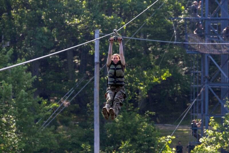 Cadet holding handles as she travels down the Slide for Life at U.S. Army ROTC Advanced Camp.  Biography of Dr. Anthony J. Carbone.