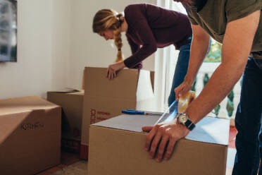 Photograph of man and girl packing boxes to move.  Autobiography of Dr. Anthony J. Carbone.