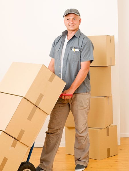 Man moving stack of boxes on a dolly to pack a moving van.  Autobiography of Dr. Anthony J. Carbone.