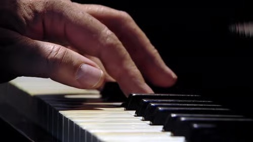 Photograph of man's hand playing the piano.  Autobiography of Dr. Anthony J. Carbone.
