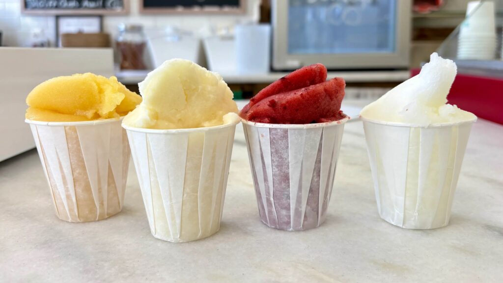 Photograph of four cups of various Italian Ice.  Autobiography of Dr. Anthony J. Carbone.