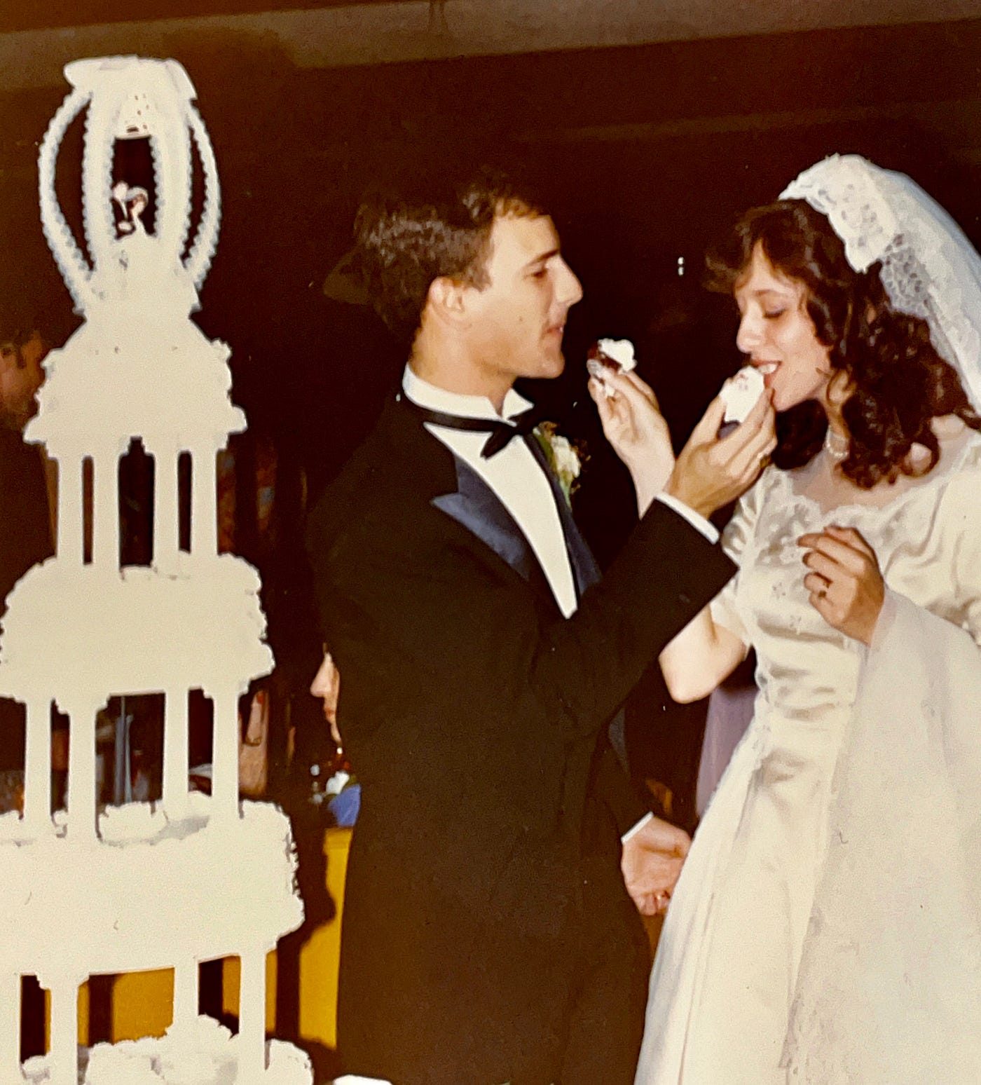 The new bride and groom (Anthony and Mariann Carbone) sharing their wedding cake.  October 30, 1982 in Wheaton, Illinois.