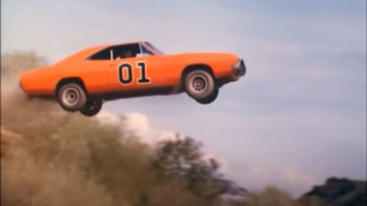 Photograph of a scene from the television series "Dukes of Hazard" with orange car Number 01 flying through the air.  Biography of Dr. Anthony J. Carbone.