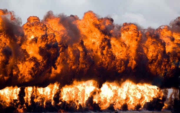 Photograph of the Wall-of-Flame with ignited napalm rising into the sky. Biography of Dr. Anthony J. Carbone.