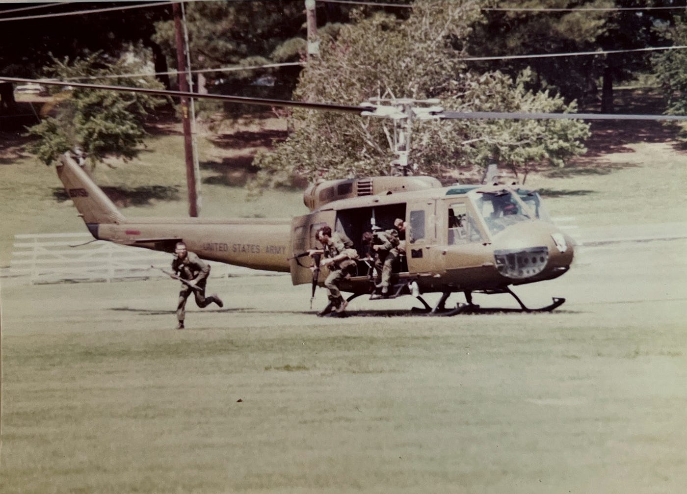 U.S. Army UH-1 Huey in an open field with Chemical Corps lieutenants running from the doors with M16s in hand. Biography of Dr. Anthony J. Carbone.