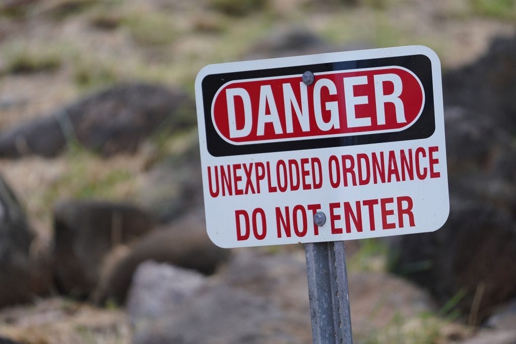 Danger, Unexploded Ordnance--Do Not Enter Sign at Fort Irwin, California.  Biography of Dr. Anthony J. Carbone.