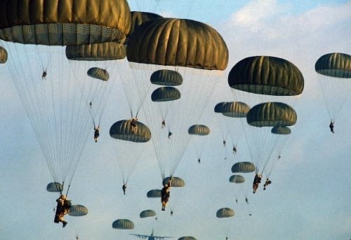Final jump before graduation.  Dozens of paratroopers under open canopies.  Biography of Dr. Anthony J. Carbone.