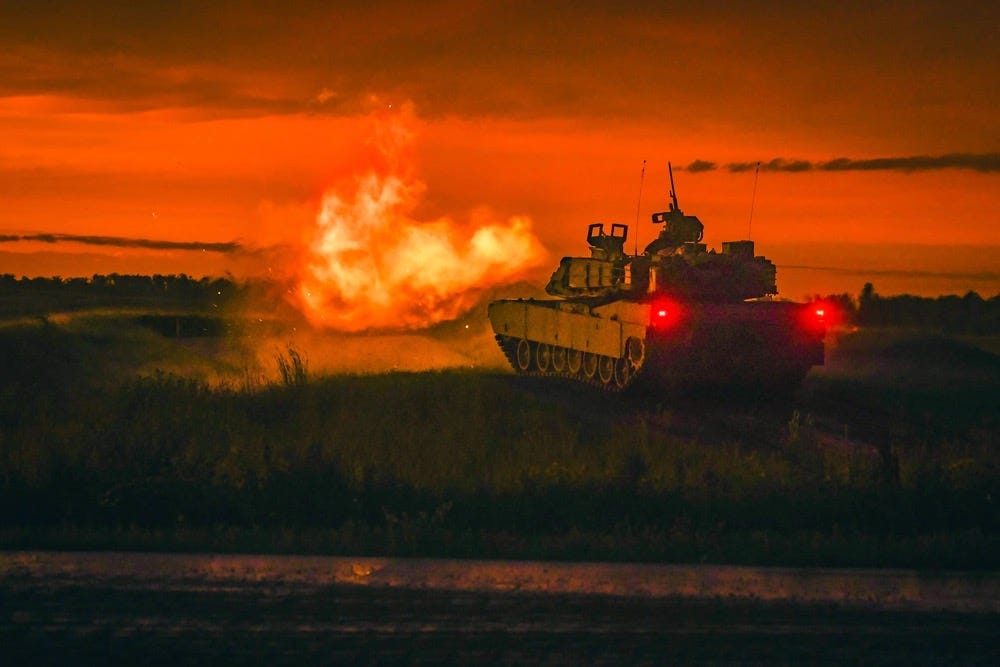 M1 Abrams tanks firing at night at the Live Fire Range at the National Training Center at Fort Irwin, California.  Biography of Dr. Anthony J. Carbone.