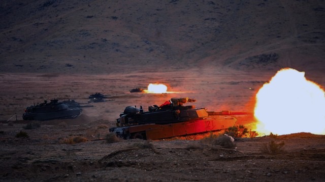 M1 Abrams tanks firing at night at the Live Fire Range at the National Training Center at Fort Irwin, California.  Biography of Dr. Anthony J. Carbone.