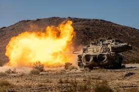M1 Abrams tanks firing at night at the Live Fire Range at the National Training Center at Fort Irwin, California.  Biography of Dr. Anthony J. Carbone.